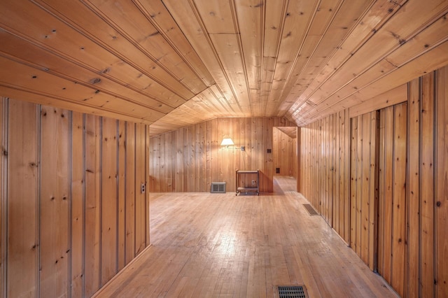 bonus room featuring lofted ceiling, wood walls, and wooden ceiling