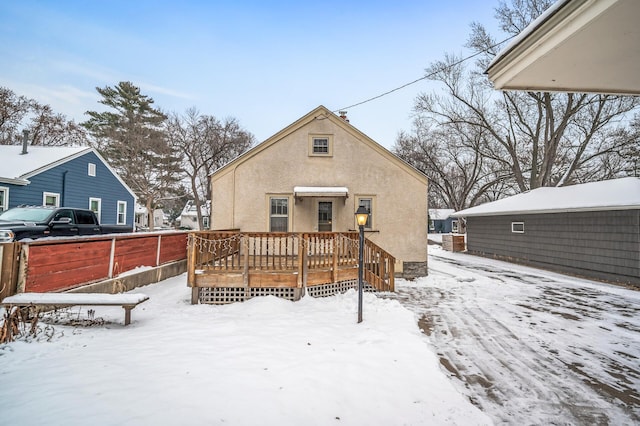 snow covered property with a deck