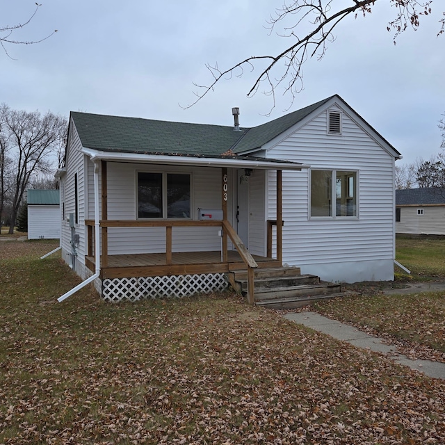 bungalow featuring covered porch and a front yard