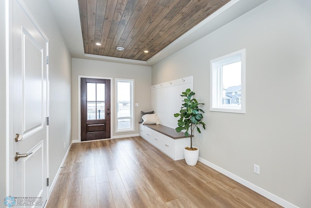 entryway with wood ceiling, light hardwood / wood-style flooring, and a raised ceiling