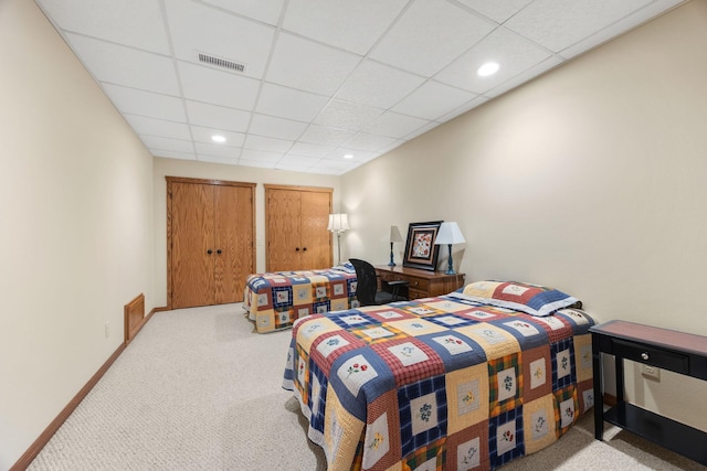 carpeted bedroom with a paneled ceiling