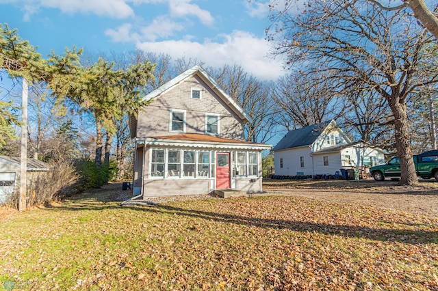 view of front of home with a sunroom and a front yard