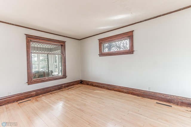 spare room featuring light hardwood / wood-style floors and crown molding