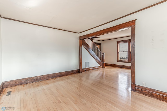 unfurnished room with light hardwood / wood-style floors and crown molding