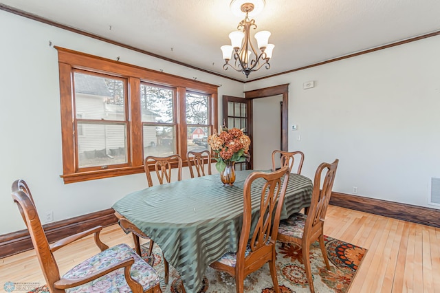 dining room featuring hardwood / wood-style floors, a notable chandelier, and crown molding