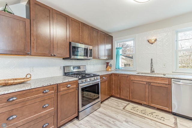 kitchen featuring a healthy amount of sunlight, sink, light hardwood / wood-style floors, and stainless steel appliances