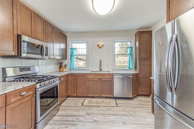 kitchen featuring a healthy amount of sunlight, light hardwood / wood-style floors, sink, and appliances with stainless steel finishes