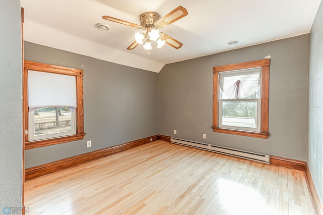 unfurnished room with baseboard heating, a wealth of natural light, light hardwood / wood-style flooring, and ceiling fan