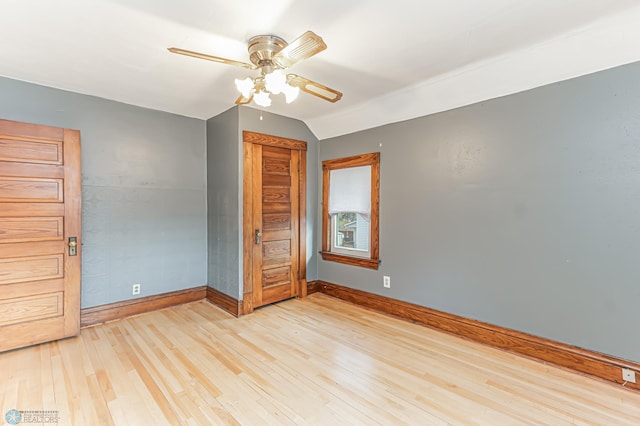 unfurnished bedroom featuring ceiling fan, vaulted ceiling, a closet, and light hardwood / wood-style flooring