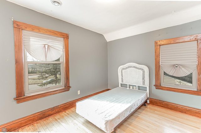 bedroom featuring light hardwood / wood-style floors and lofted ceiling