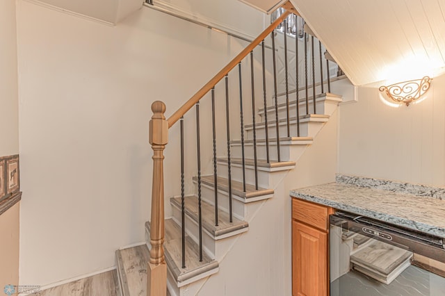 staircase featuring hardwood / wood-style flooring and bar area