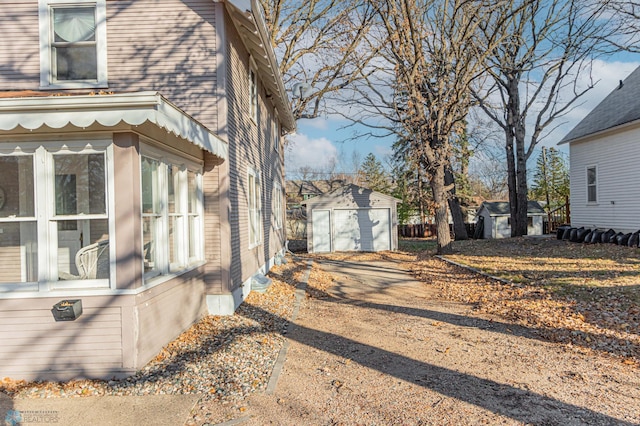 view of side of home with a garage and an outbuilding