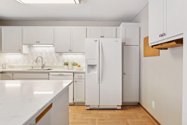 kitchen featuring white appliances, backsplash, light parquet floors, sink, and white cabinetry