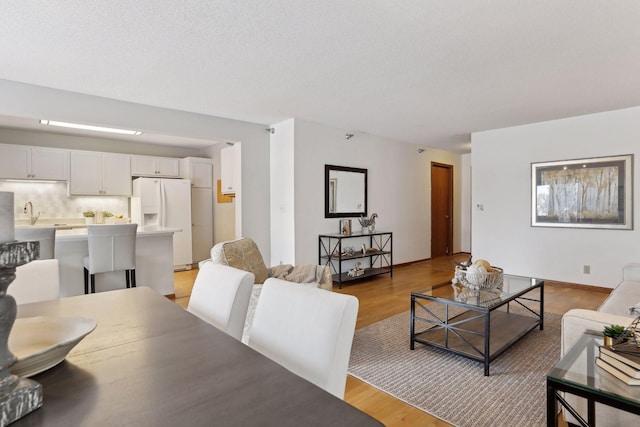 living room with a textured ceiling and light wood-type flooring