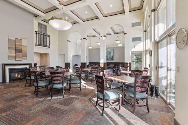 dining area featuring beam ceiling, a towering ceiling, dark carpet, and coffered ceiling