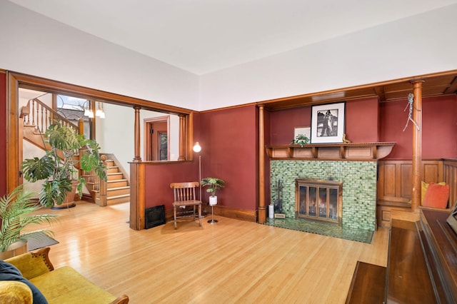 living room with a tiled fireplace and wood-type flooring