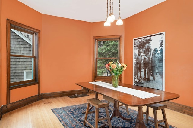 dining area with hardwood / wood-style flooring and an inviting chandelier