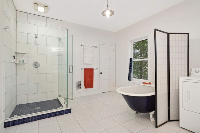 bathroom featuring washer / clothes dryer, tile patterned floors, and separate shower and tub