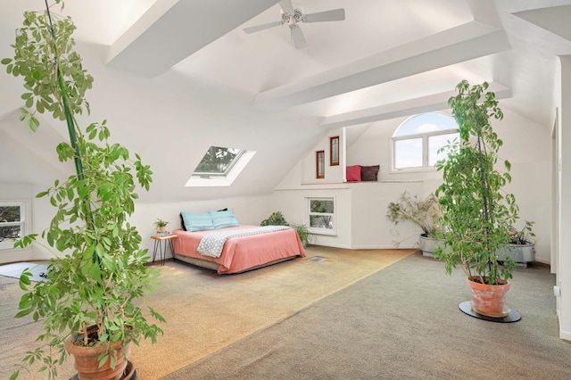 bedroom with lofted ceiling with skylight, carpet floors, and ceiling fan