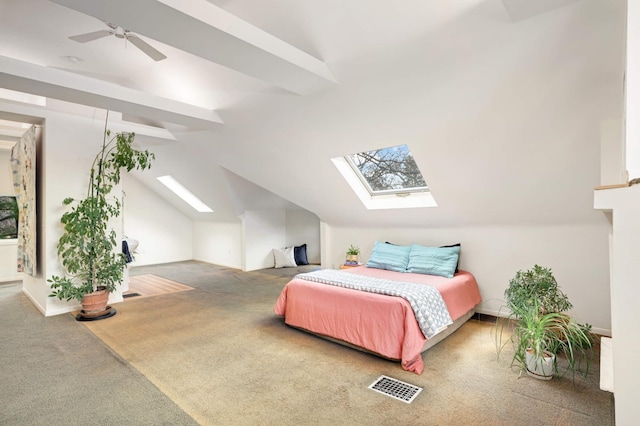 bedroom with lofted ceiling with skylight, ceiling fan, and carpet