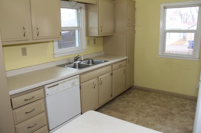 kitchen with a wealth of natural light, cream cabinets, dishwasher, and sink