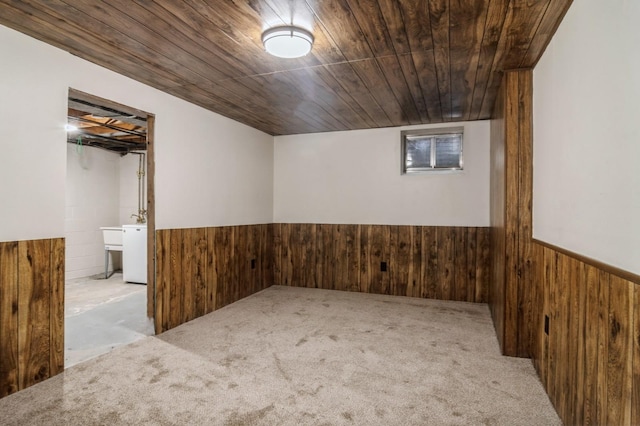 empty room featuring wood walls, light colored carpet, and wooden ceiling