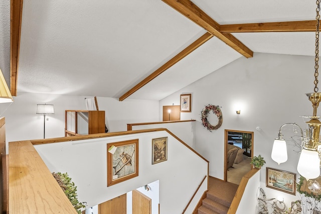 staircase featuring lofted ceiling with beams and a textured ceiling