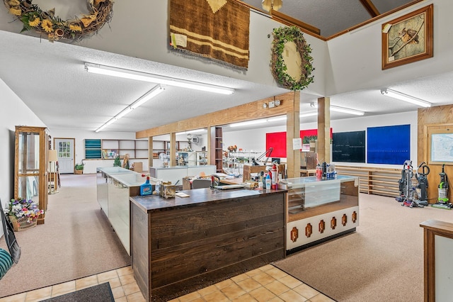 kitchen with dark brown cabinetry, a textured ceiling, and light tile patterned floors