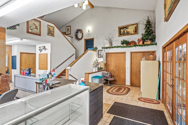 kitchen featuring white refrigerator, lofted ceiling, french doors, and light tile patterned flooring