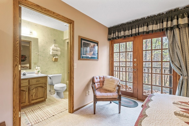 bedroom featuring connected bathroom, sink, and french doors