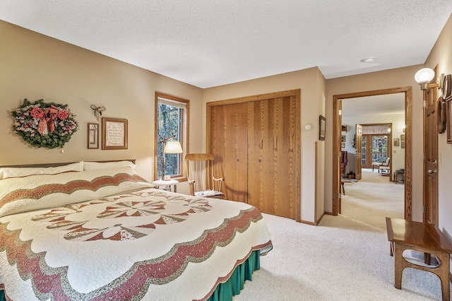 carpeted bedroom with a closet and a textured ceiling