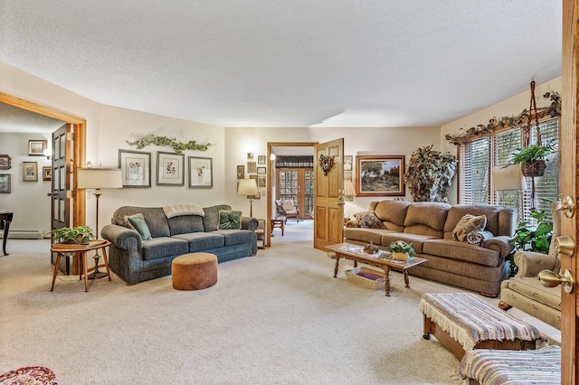 carpeted living room with a baseboard heating unit and a textured ceiling