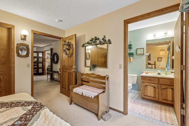 carpeted bedroom with a textured ceiling and ensuite bath