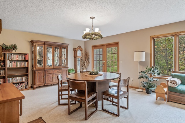 carpeted dining area featuring a textured ceiling, french doors, and a notable chandelier