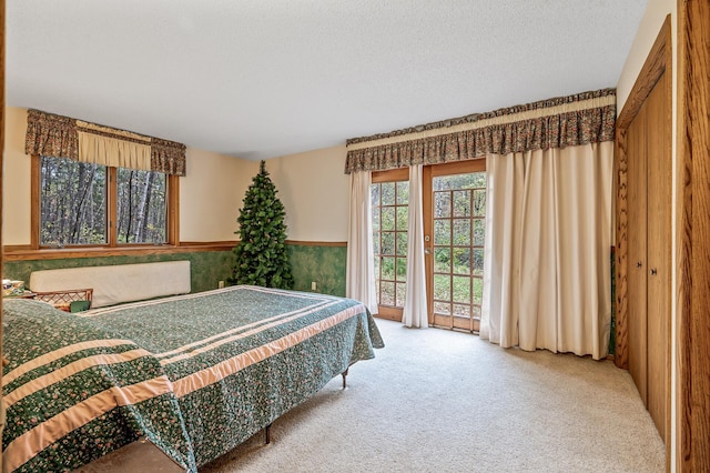 carpeted bedroom featuring access to outside and a textured ceiling