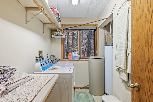 washroom with washer and clothes dryer and a textured ceiling