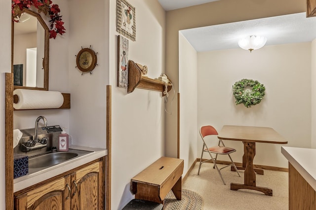 hall featuring light colored carpet and sink