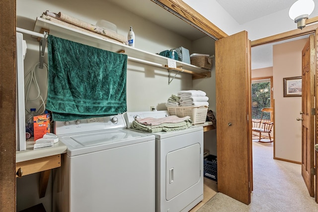 laundry area featuring light colored carpet and washer and clothes dryer