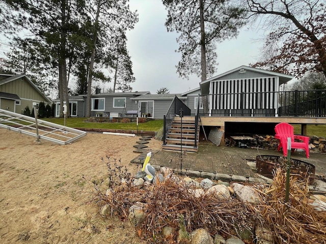 exterior space featuring a deck, a patio area, and a fire pit