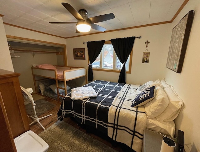 bedroom featuring ceiling fan, dark hardwood / wood-style flooring, a closet, and crown molding