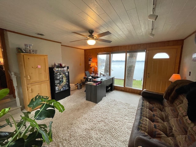 carpeted living room with a water view, ceiling fan, wood ceiling, and wooden walls