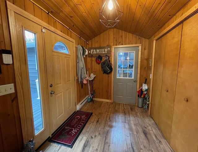 foyer with hardwood / wood-style flooring, wood walls, wooden ceiling, a baseboard radiator, and vaulted ceiling