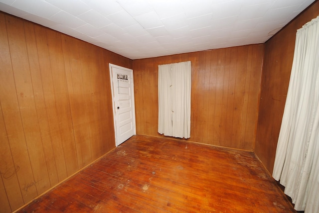 empty room featuring dark wood-type flooring and wood walls