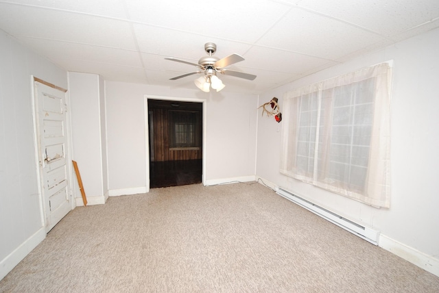 empty room featuring a paneled ceiling, carpet flooring, ceiling fan, and a baseboard heating unit