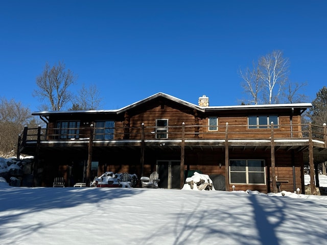 view of snow covered rear of property