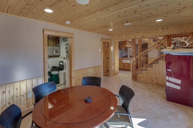 dining room with wood walls, wood ceiling, and light tile patterned flooring