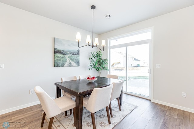 dining space featuring an inviting chandelier and light hardwood / wood-style floors