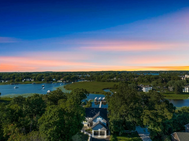 aerial view at dusk featuring a water view