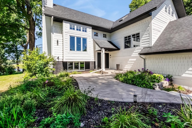 4756 Kildare Rd, Mound, MN 55364 - view of front of house featuring a patio area, a chimney, and a shingled roof