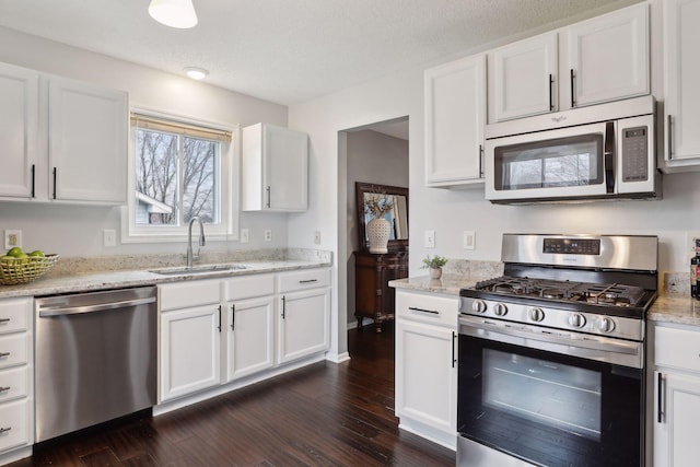 kitchen with sink, white cabinets, dark wood-type flooring, and appliances with stainless steel finishes